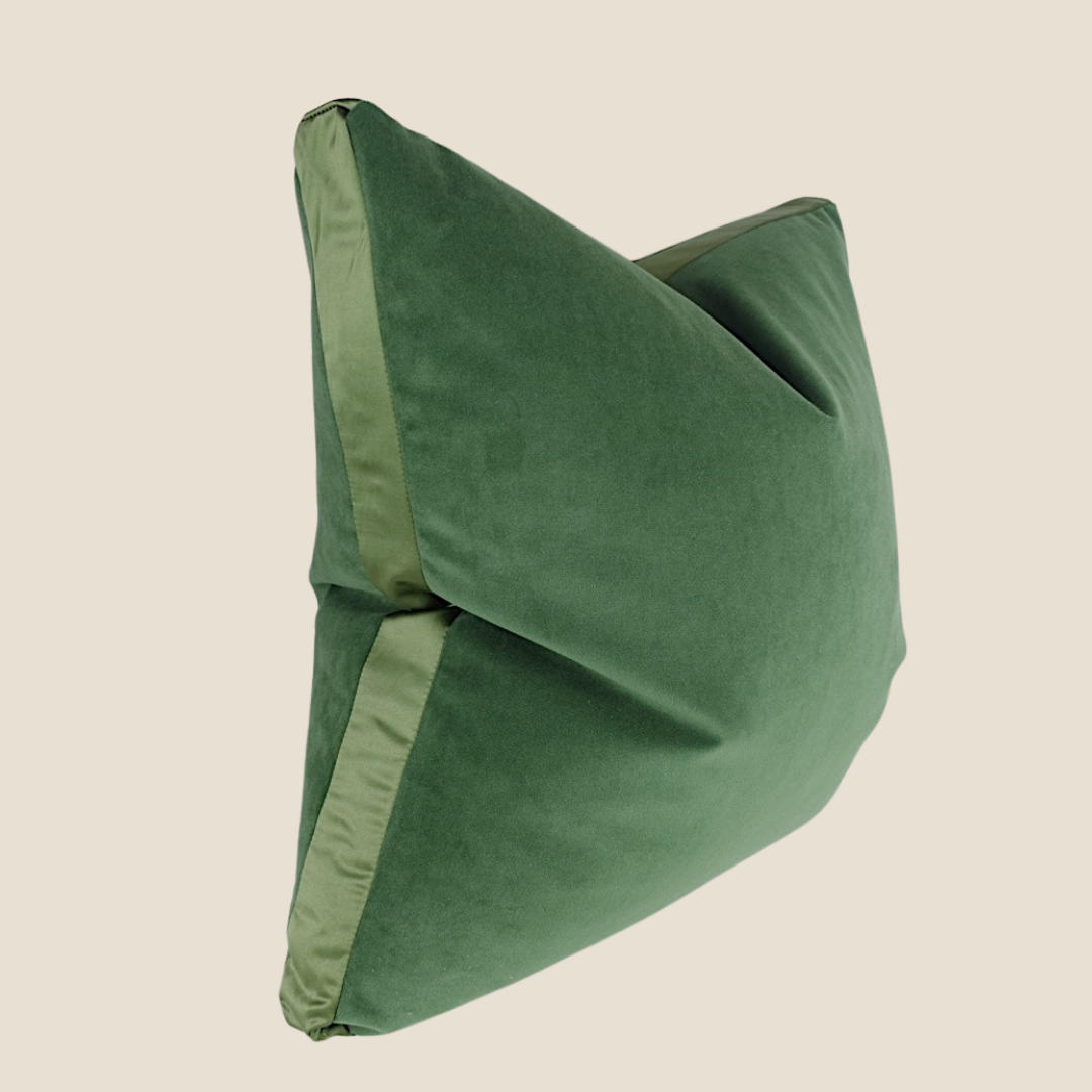 a green velvet cushion on a white background